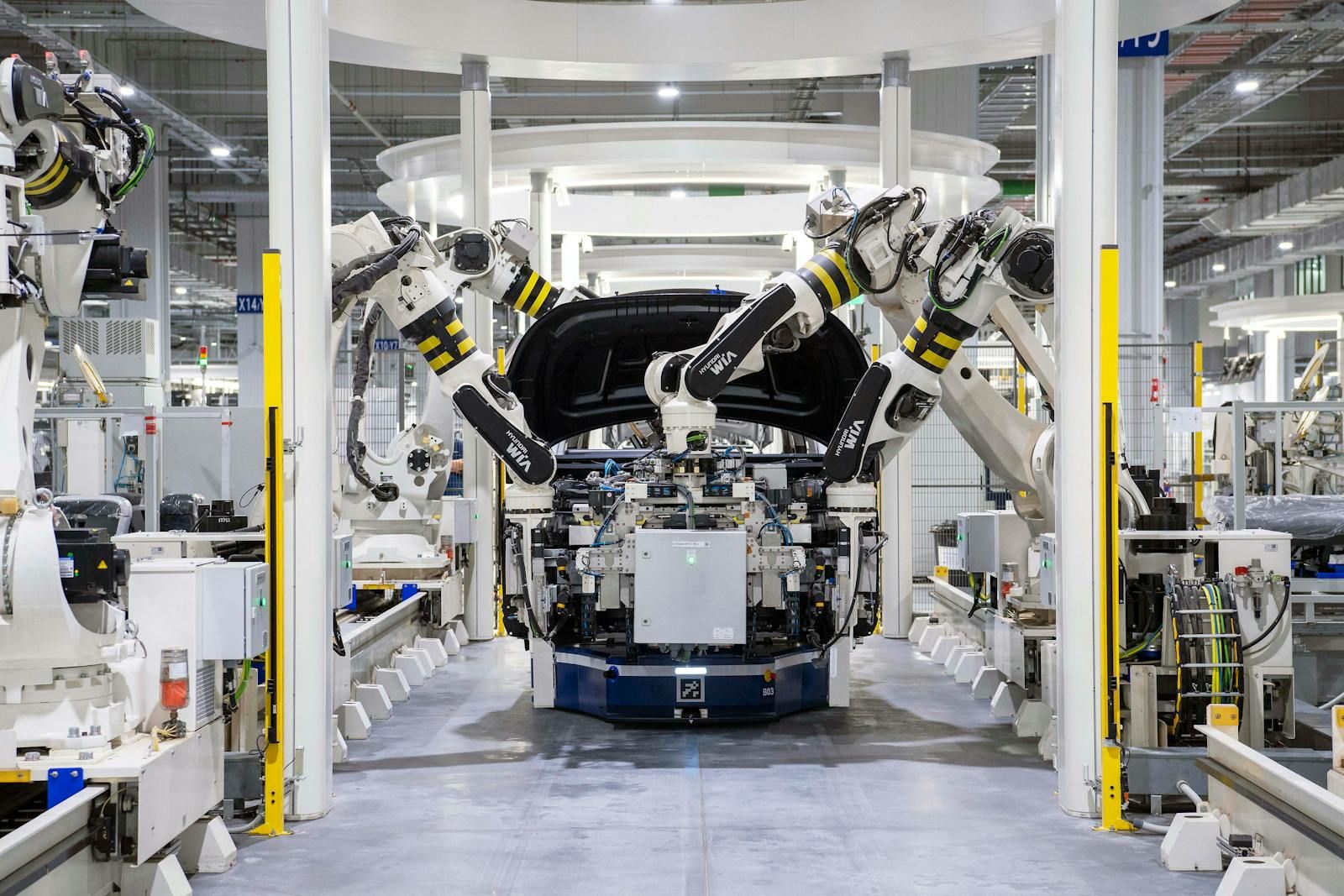 Robotic arms assembling vehicles on an automotive production line